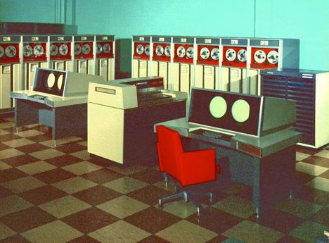 A room with a classical mainframe computer and work desks